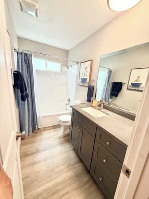 Regadera, secadora de cabello, toallas, papel de baño 