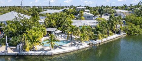 Una zona residencial con casas, piscina y acceso al agua.