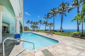 A pool area with a clear view of the ocean, surrounded by palm trees and a building with a white facade. - SUMMER SALE! Beachfront Remodeled Studio Stunning Views - Lahaina Shores 607 (Lahaina)