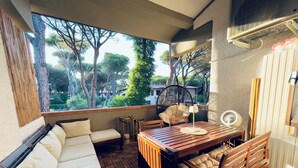 A cozy outdoor seating area with a wooden table, chairs, and a cushioned bench.