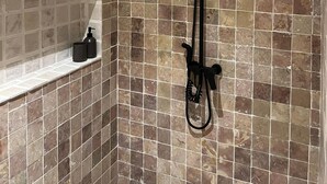 Une douche équipée d’un pommeau de douche à main et d’un pommeau de douche à main avec un flexible.