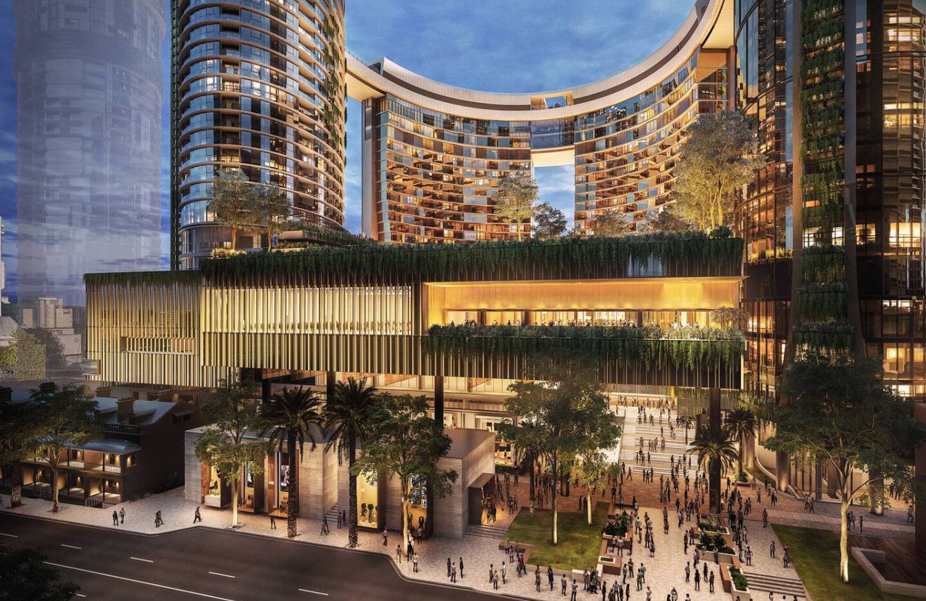 A modern hotel with a curved facade, multiple balconies, and a spacious outdoor area with trees and seating.