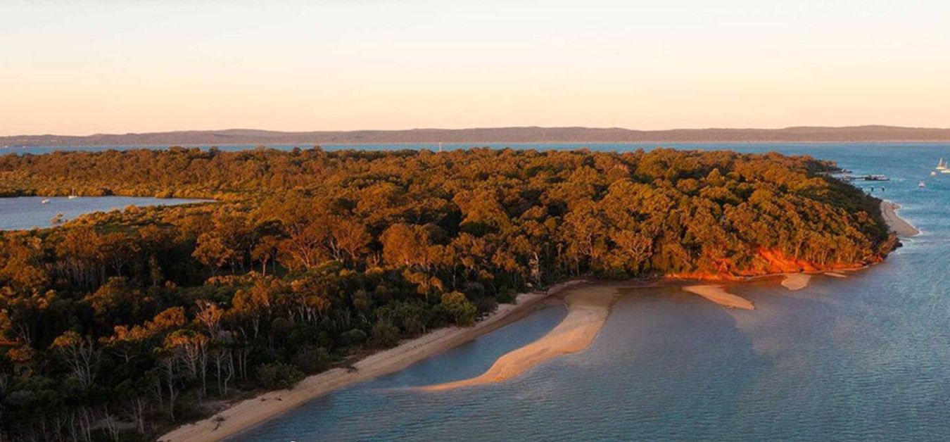 An aerial view of Cochiemudlo Island with a beach and dense forest.