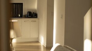 A modern kitchen with white cabinets, a black countertop, and a coffee machine. - Spacious 5BR Home in Heart of Sunnybank |Sleeps 10 (Sunnybank)
