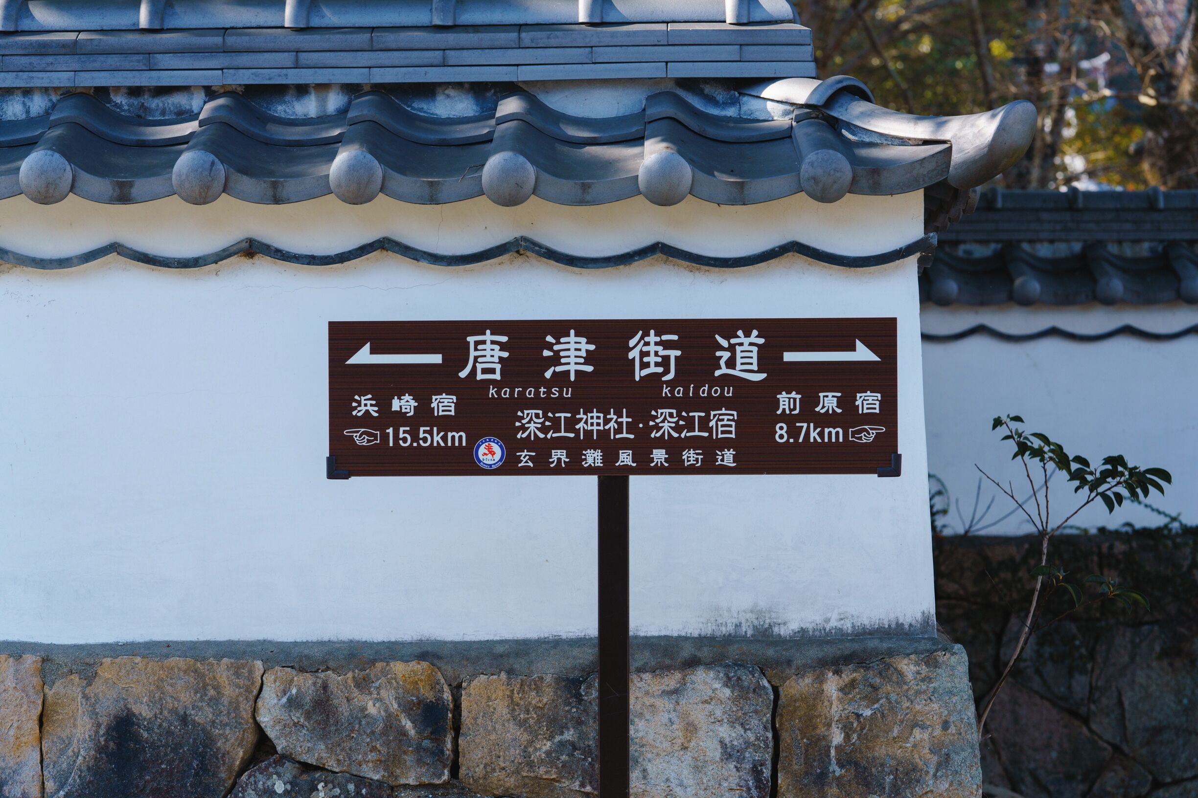 A sign with directional arrows and distances to nearby locations.