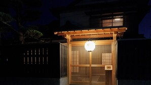Un tradizionale cancello giapponese con struttura in legno e un lanterne illuminata.