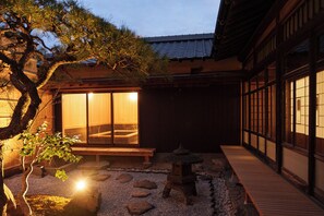 A traditional Japanese building with a wooden exterior, a stone pathway, and a wooden bench. - Historic Kominka in Itoshima - One-Group-Per-Day (糸島市二丈深江)