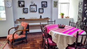 A dining area with a wooden table and chairs, a clock on the wall, and a 'welcome' sign above a shelf. - Apartment 3 Bedrooms | next to Delgado Clinic in Miraflores (Miraflores)