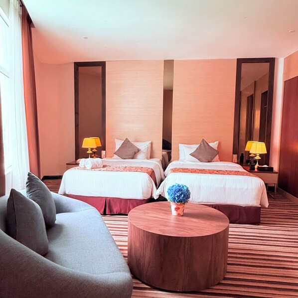 A hotel room with two beds, a sofa, a round coffee table, and a mirror. - The Pure Hotel Langkawi (Langkawi)