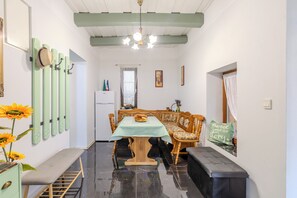 Ein Essbereich mit Tisch für zwei Personen, einer Bank und einem an der Wand befestigten Hakenleiste.