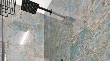 Une salle de bain moderne avec un mur en marbre, une pomme de douche noire et une paroi de douche en verre.
