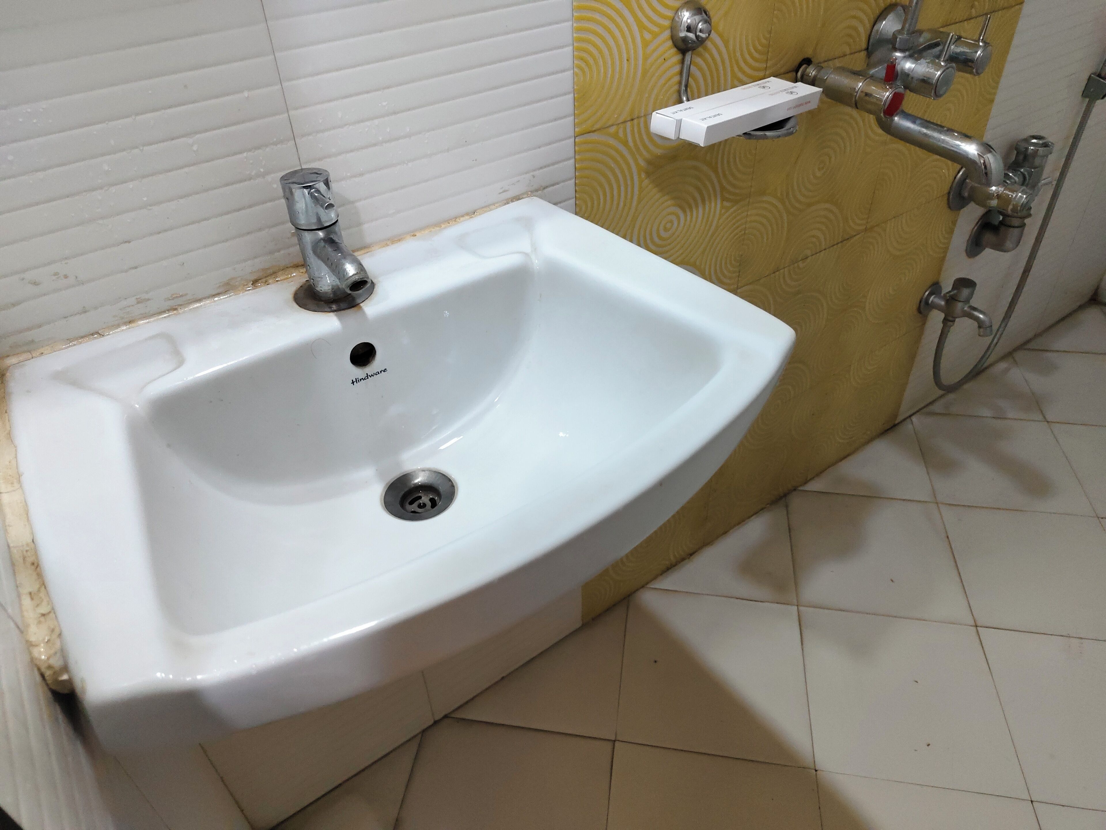 A bathroom sink with a drain, a faucet, and a soap dispenser.