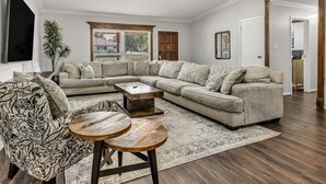 A spacious living room with a sectional sofa, a patterned armchair, and a coffee table.