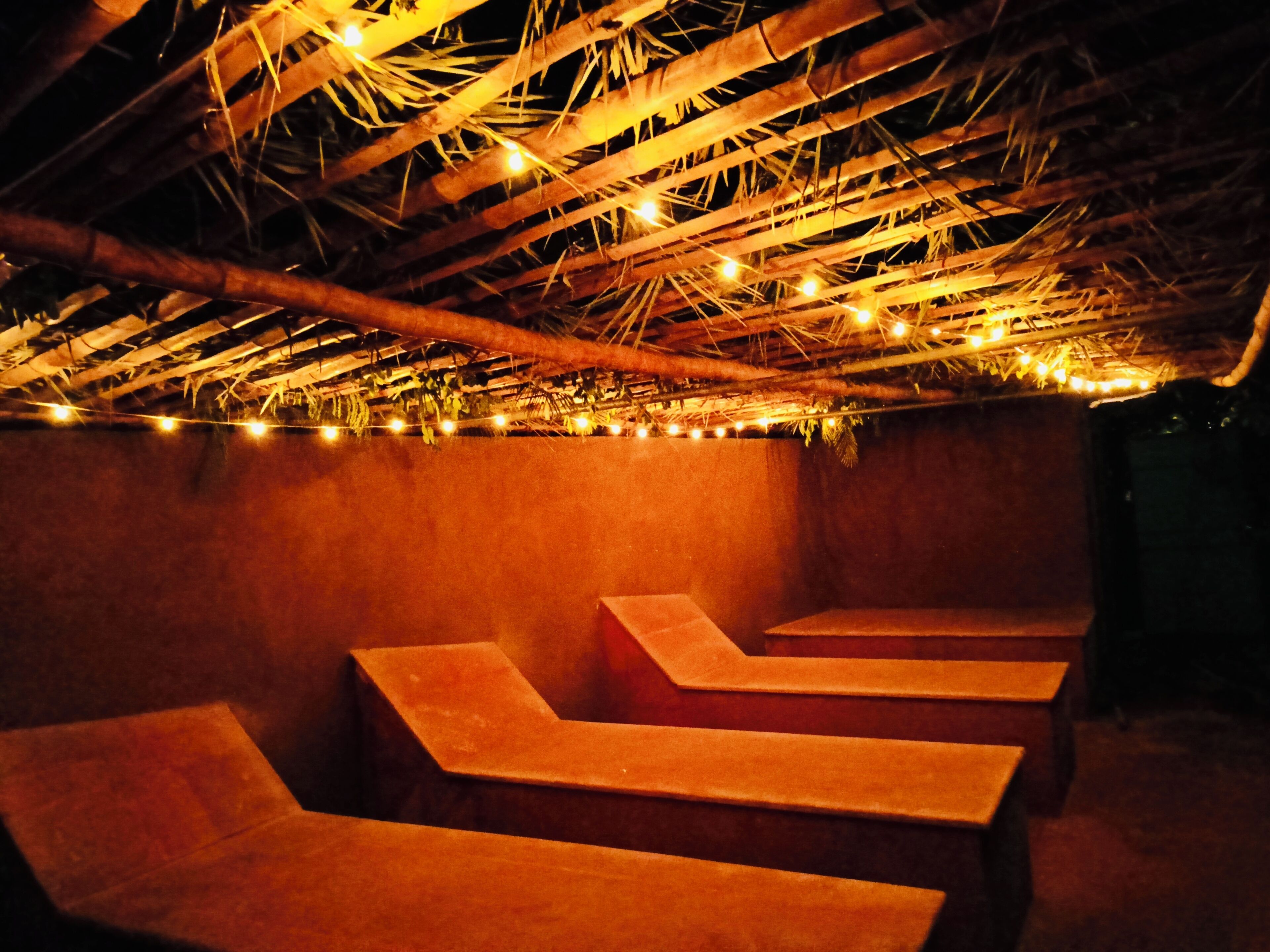 Une pièce faiblement éclairée, avec des bancs en bois disposés en demi-cercle.
