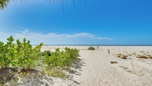 A sandy beach with a clear sky, a path leading to the ocean, and some vegetation. - < 1 Mi to Fort Myers Beach: Bayfront Condo w/ Pool (Fort Myers Beach)