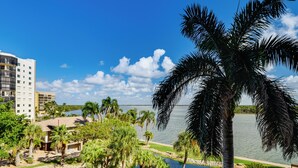A resort with a pool, palm trees, and a view of the water. - < 1 Mi to Fort Myers Beach: Bayfront Condo w/ Pool (Fort Myers Beach)