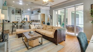 A spacious living room with a large sectional sofa, a coffee table, and a ceiling fan. - Forested Wimauma Retreat 2 Mi to State Park! (Wimauma)
