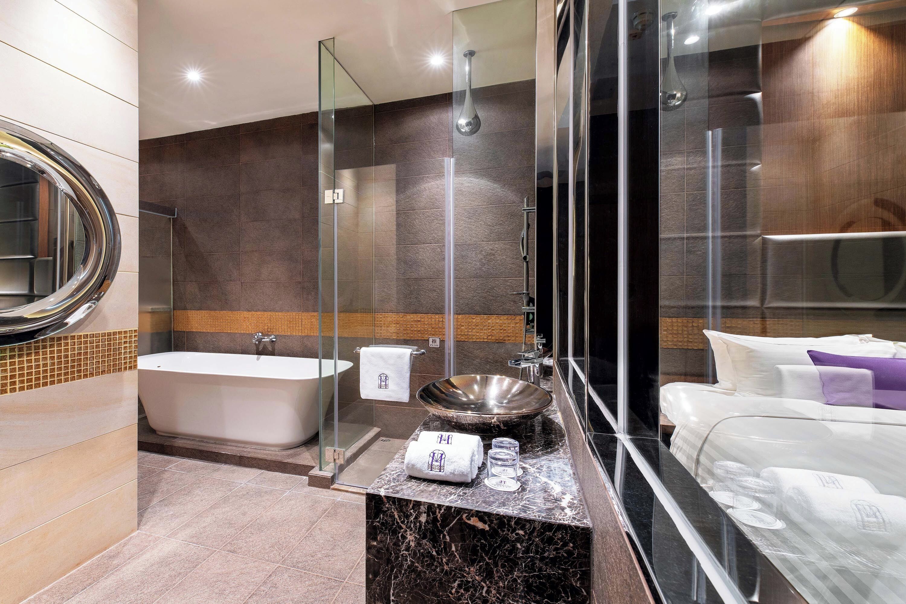 A modern bathroom with a freestanding bathtub, a large sink, and a glass-enclosed shower.