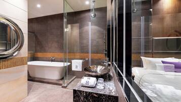 A modern bathroom with a freestanding bathtub, a large sink, and a glass-enclosed shower.