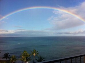 A view of the ocean with a rainbow arching over it.
