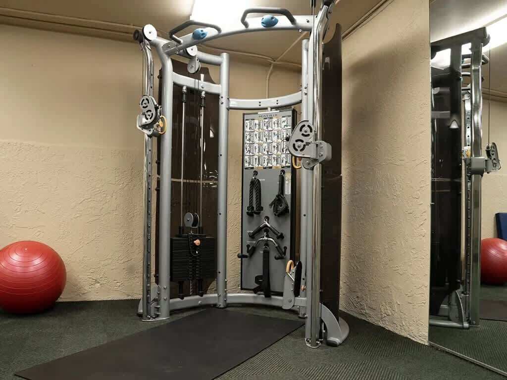 Ein Fitnessraum mit Hantelgestell, Gewichtbank und Übungsbällen.