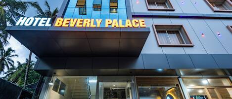 The exterior of Hotel Beverly Palace with a modern design, large windows, and a prominent sign.
