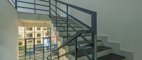 A modern staircase with metal railings and dark granite steps.