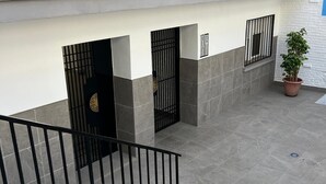 A staircase leading to a gated entrance with a potted plant nearby. - Torremolinos Center, Magnificent Air-conditioned Apartment, Wifi, Beautiful (Torremolinos)