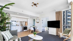 A modern apartment with a living room, dining area, kitchen, and bedroom.