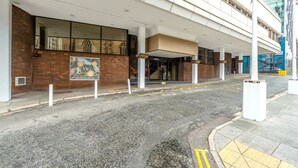 A hotel entrance with a covered walkway, a brick facade, and a poster on the wall. - Atlantic Tower Hotel By Sunday - Classic Twin Room (Liverpool)