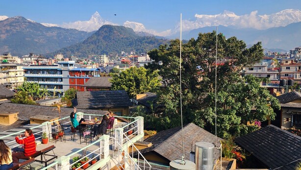 A residential area with a view of mountains in the background. - Kiwi Backpackers Hostel (Pokhara)