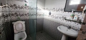A bathroom with a toilet, sink, and glass shower enclosure. - Kiwi Backpackers Hostel (Pokhara)