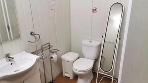 A bathroom with a white sink, toilet, and a mirror. - Bungalow by the sea Cozy We accept pets (Costa da Caparica)