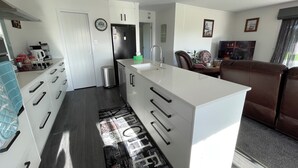 A modern kitchen with white cabinetry, a built-in island, and a stainless steel sink.