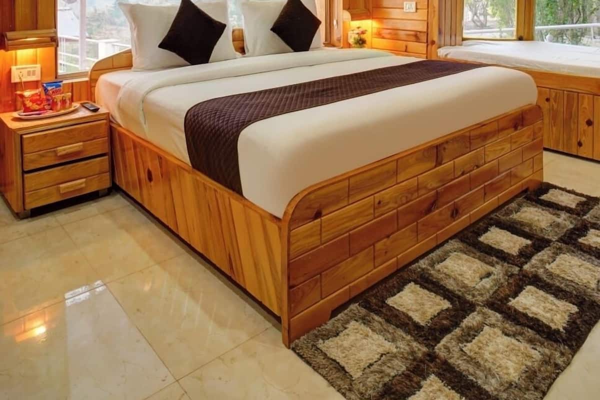 A wooden-paneled bedroom with a large bed, two bedside tables, a ceiling fan, and a view of the outdoors.