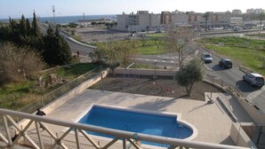 Una zona residencial con piscina, carreteras y edificios al fondo.