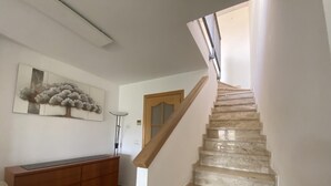 Una escalera con barandilla de madera que lleva a una plataforma.