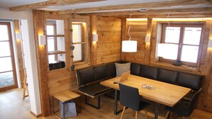Un interior de madera con un banco, una mesa y una computadora portátil.