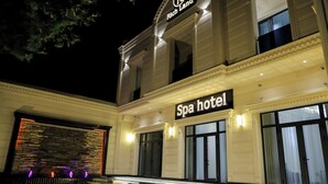 Un hôtel avec spa, doté d’une façade en pierre, de grandes fenêtres et d’une enseigne au-dessus de l’entrée.