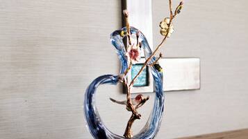 Una escultura de vidrio decorativa sobre un mueble de madera con un marco de fotos colgado en la pared.