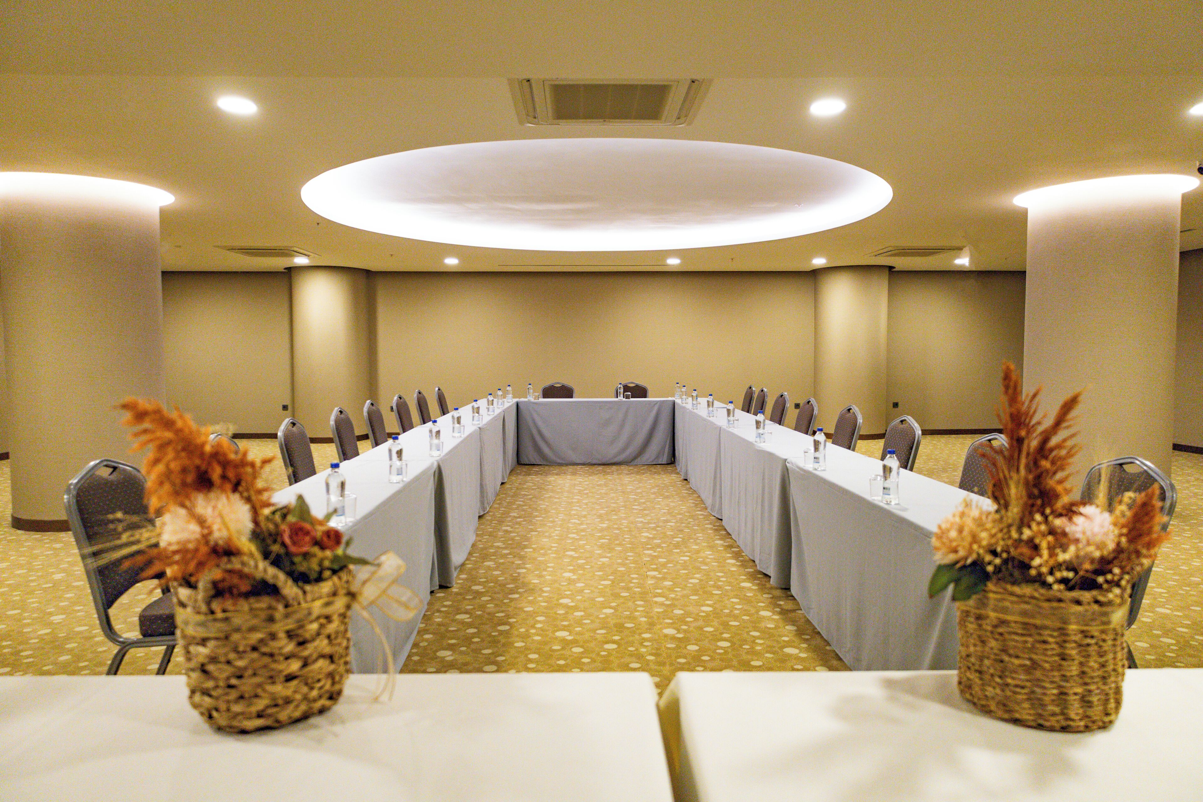 A conference room with a long table, chairs, and a carpeted floor.