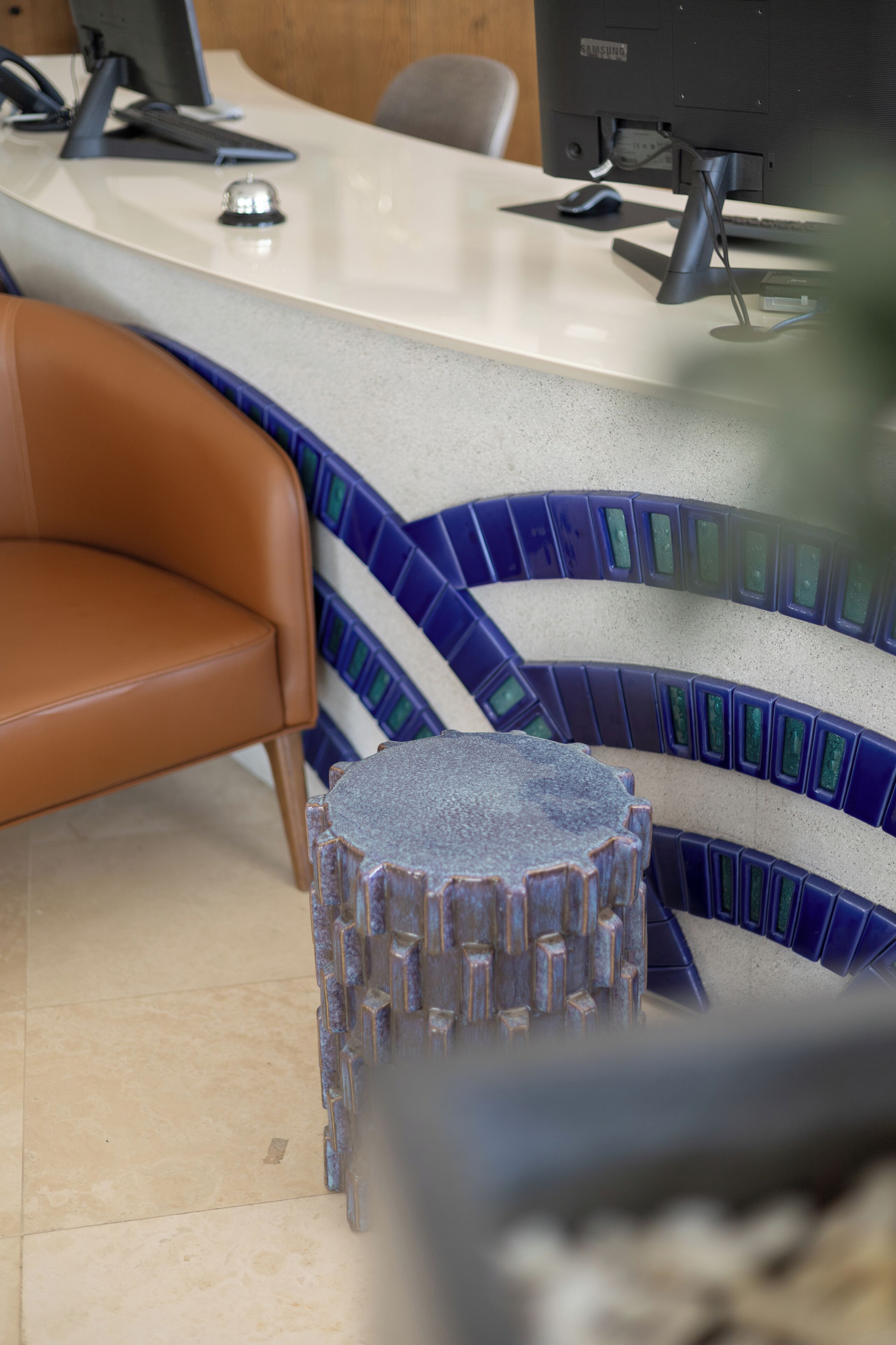 A reception desk with a computer, a telephone, and a small bell.