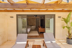 Ein moderner Außenbereich mit zwei Lounge-Stühlen, einer Holzpergola und einem Blumentopf.