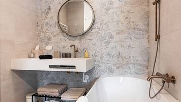 Un bagno moderno con una vasca freestanding, un mobile lavabo con specchio e una zona doccia.