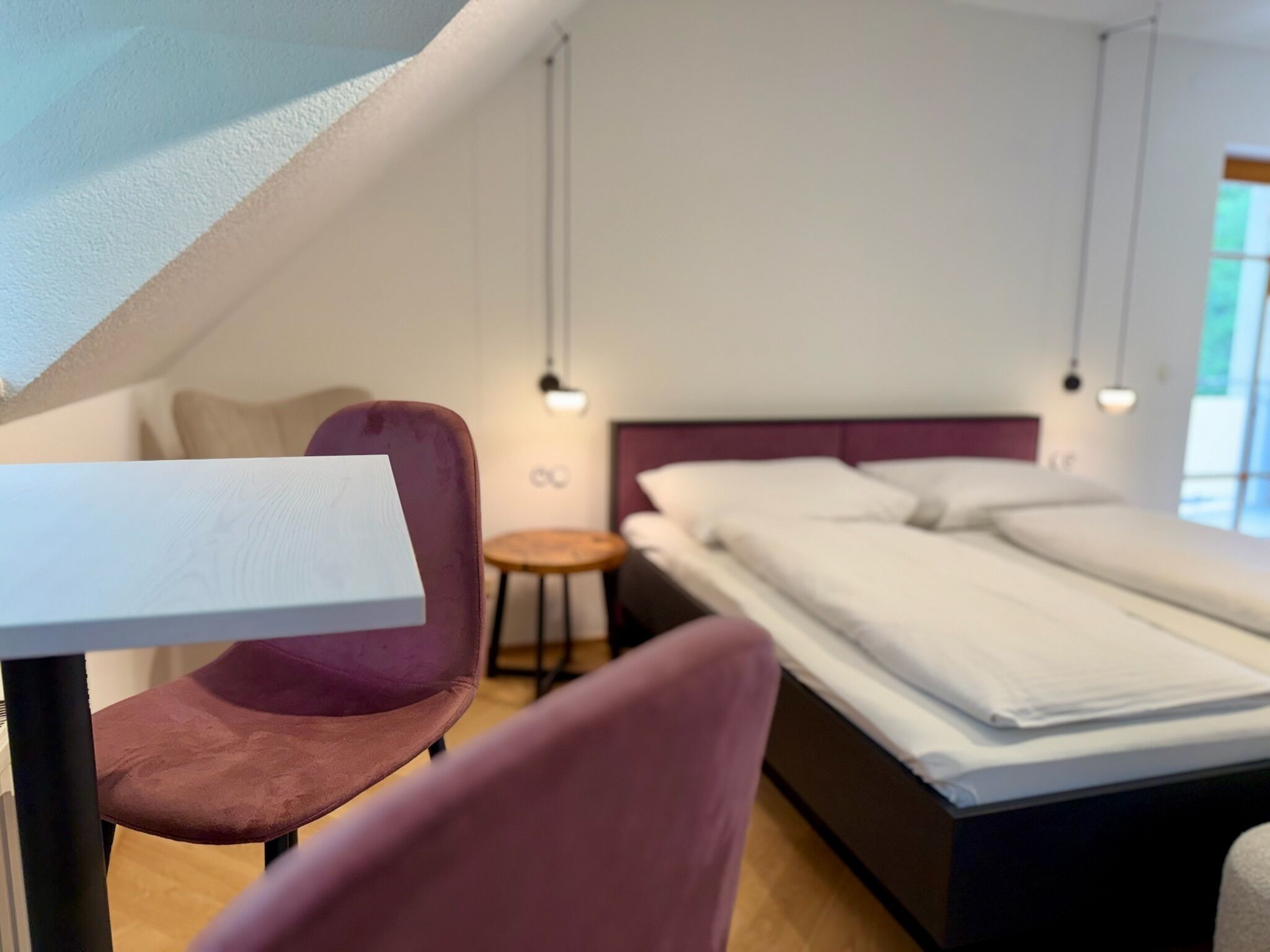Ein modernes Schlafzimmer mit Bett, Schreibtisch und Stuhl.