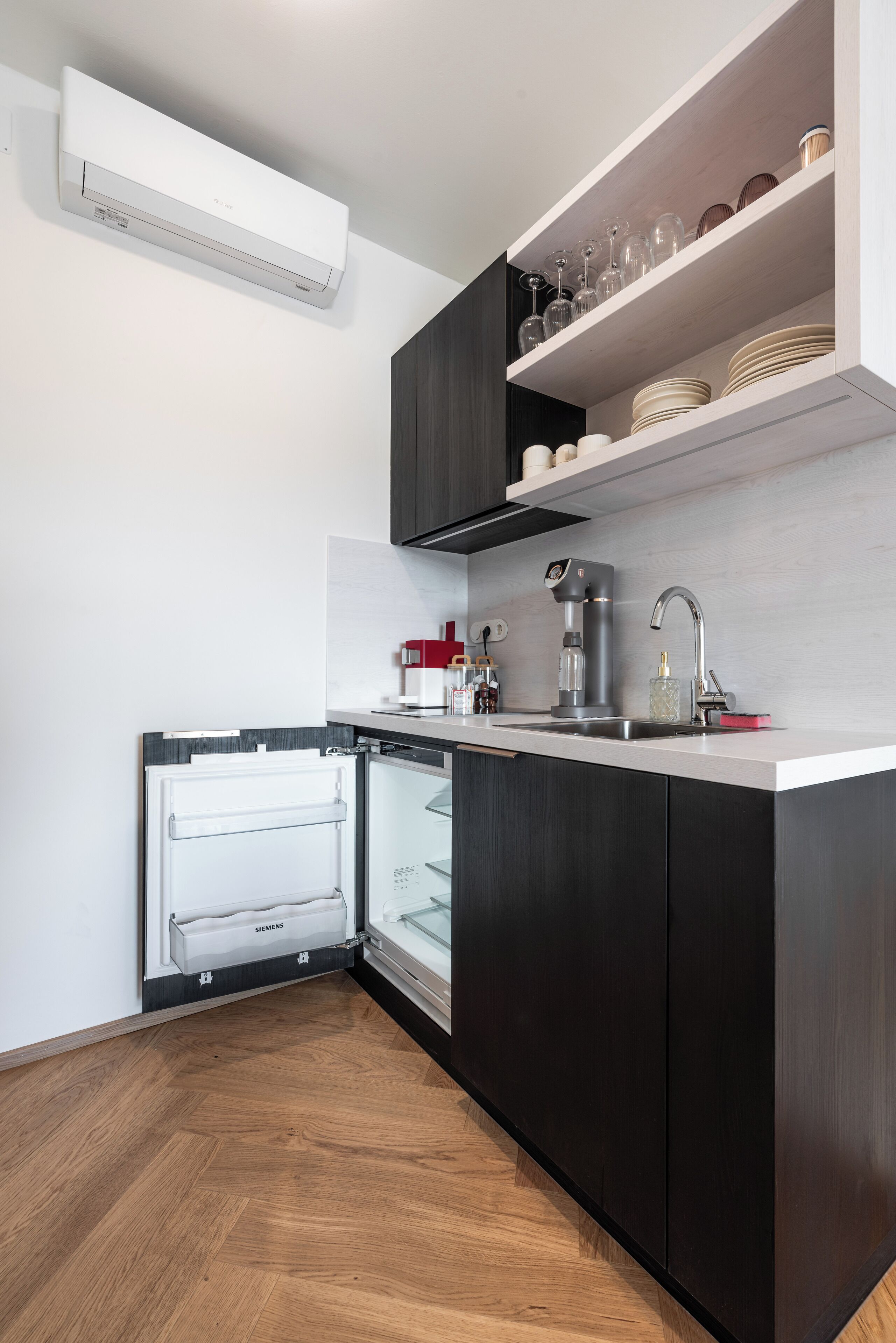 A modern kitchen with a built-in refrigerator, a coffee machine, and a wine rack.