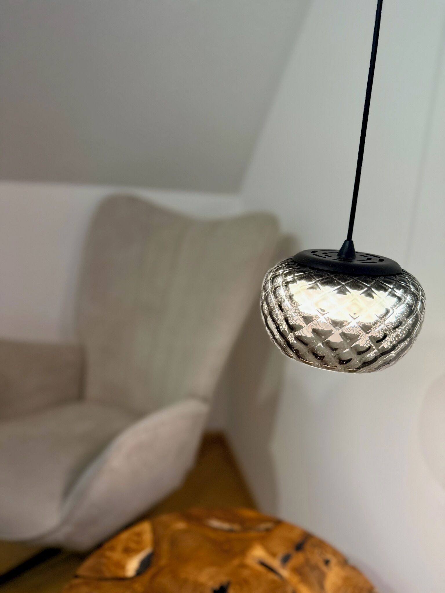 Una lampada a sospensione con finitura metallica strutturata.