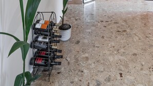 Un interior moderno con un botellero, estantes con cristalería y una encimera de madera.