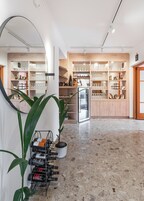 Un interior moderno con un botellero, estantes con cristalería y una encimera de madera.