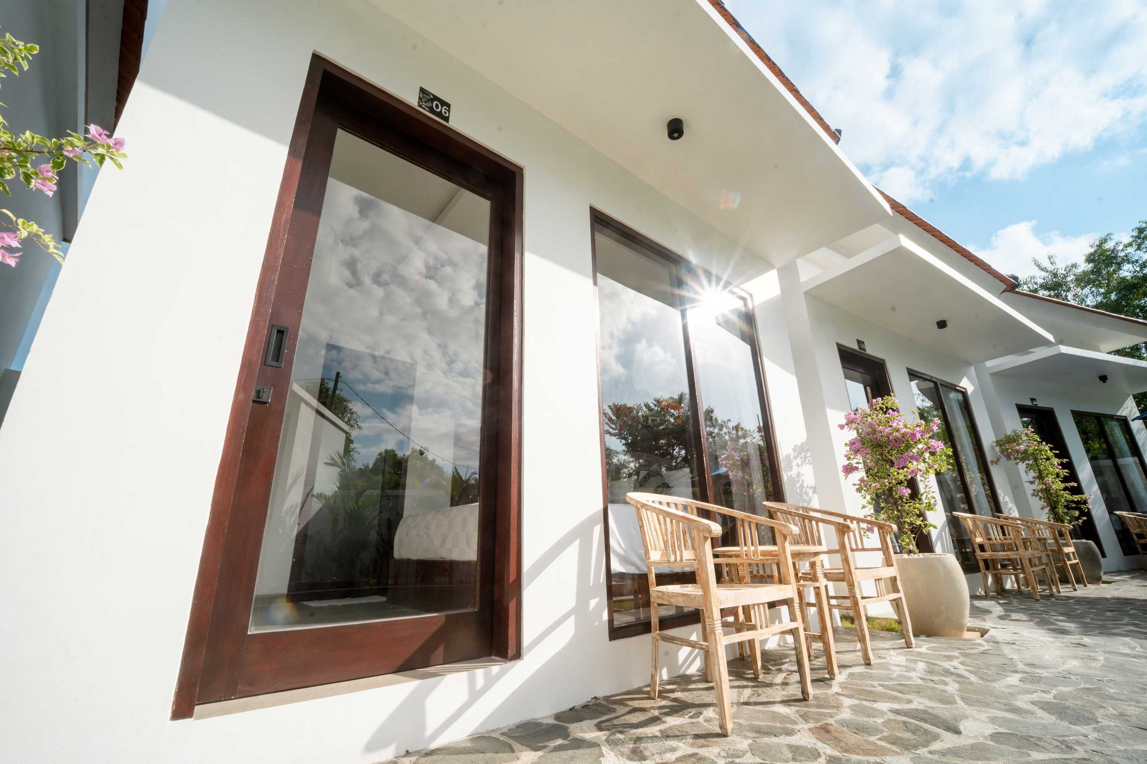 A building with large windows, outdoor seating, and a stone-paved area.